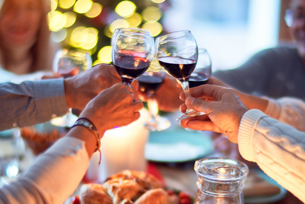 people eating dinner and toasting with wine